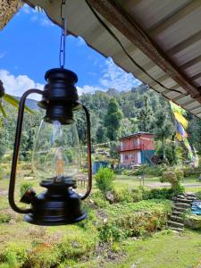 an old lantern hanging from the roof of a house at Chopta Eco Cottage & Camping in Sari