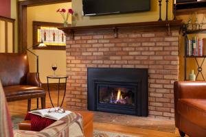a living room with a fireplace with a tv above it at The Buckingham Inn in Madison