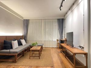 a living room with a couch and a table at GalileOasis Boutique Hotel in Bangkok