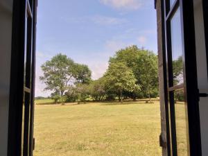 a view of a field from a window at Maison calme avec grand jardin en Berry, proche Châteauroux - FR-1-591-372 in Arthon