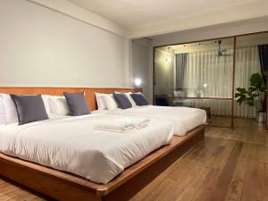 a bedroom with a large bed with white sheets at GalileOasis Boutique Hotel in Bangkok