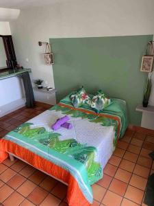 - une chambre avec un lit fleuri dans l'établissement Studio paisible avec piscine, pas loin de la plage, à La Trinité