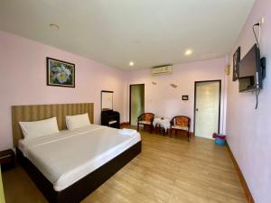 a bedroom with a bed and a table and chairs at Pachumas Hotel in Karon Beach