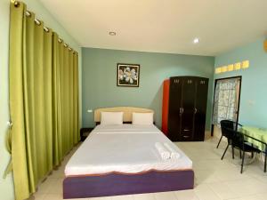 a bedroom with a bed and a table in a room at Pachumas Hotel in Karon Beach +4 photos