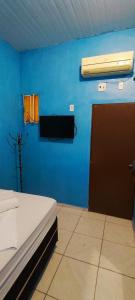 a bedroom with a blue wall with a door and a fan at Sol de Iracema centro in Fortaleza