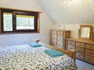 ein Schlafzimmer mit einem Bett, zwei Kommoden und einem Fenster in der Unterkunft Glen Rosa in Dalrymple