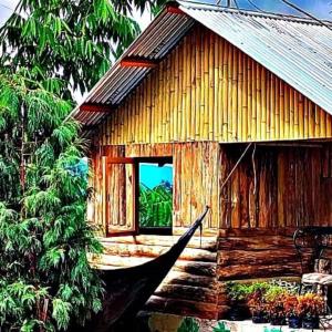 un pequeño edificio de madera con ventana y porche en Rongong Farmstay by StayApart, en Māngwa