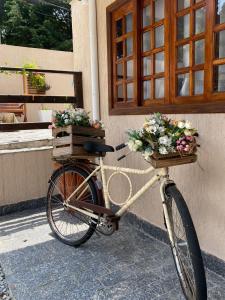 ein Fahrrad mit zwei Körben und Blumen drauf in der Unterkunft Villaggio Cascate in Campos do Jordão