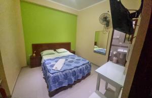 Dormitorio pequeño con cama y espejo en Hospedaje Paraíso, en Tingo María