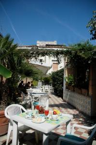 una mesa blanca y sillas en un patio en Hotel Toledo en Nápoles