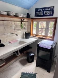 a kitchen with a sink and a sign on the wall at Chalé Gaia - Itatiaia in Itatiaia