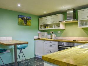 a kitchen with a cow picture on the wall at The Cottage - Ukc6140 in Cartmel