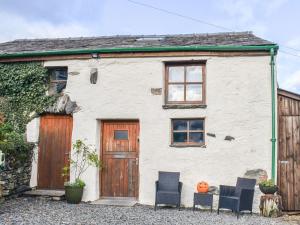a white house with two chairs and a pumpkin at The Cottage - Ukc6140 in Cartmel