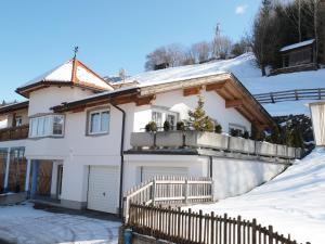 una casa blanca con una cerca en la nieve en Appart Gabl, en Arzl im Pitztal