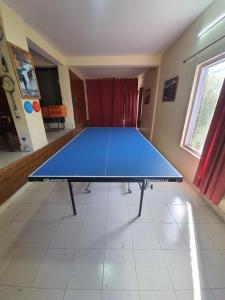 una mesa de ping pong en el medio de una habitación en Majkhali Woods, Ranikhet, By Himalayan Eco Lodges, en Rānīkhet