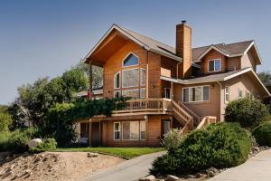a large house with a porch and a deck at Epic View; A Luxury House on a Hill in Kernville