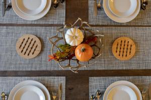 a table with white plates and pumpkins on a table at Epic View; A Luxury House on a Hill in Kernville