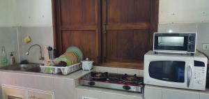 a kitchen with a microwave and a stove and a sink at SeeSea Thai wooden house on beachfront in Prachuap Khiri Khan