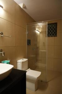 a bathroom with a toilet and a glass shower at Shri Mahamaya in Panaji