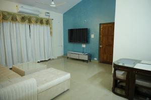 uma sala de estar com um sofá e uma televisão em Shri Mahamaya em Panaji
