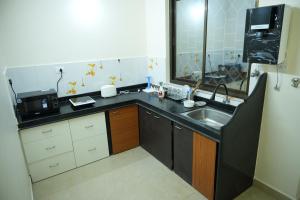 a small kitchen with a sink and a microwave at Shri Mahamaya in Panaji