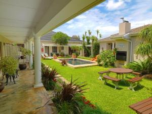 a backyard with a picnic table and a pool at Beachwalk Bed and Breakfast - #Solar Energy #No Loadshedding in Port Elizabeth