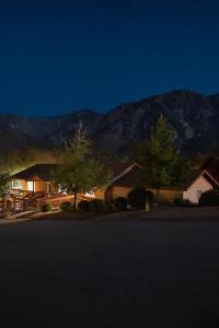 a house at night with a mountain in the background at Lazy Squirrel - Cozy Family House with Full Game Room in Kernville