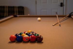 a group of billiard balls on a pool table at Lazy Squirrel - Cozy Family House with Full Game Room in Kernville
