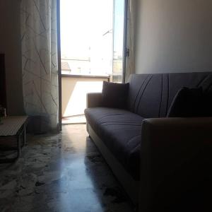 a living room with a couch and a large window at Casa di Mattia in Pescara