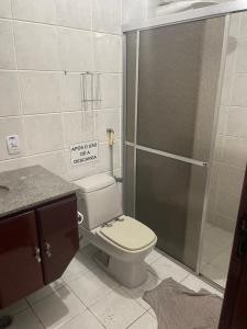 a bathroom with a toilet and a shower with a glass door at Pousada Lifestyle Ilhabela in Ilhabela
