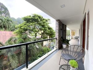 a balcony with a table and chairs and trees at Bill Tourist Inn in El Nido