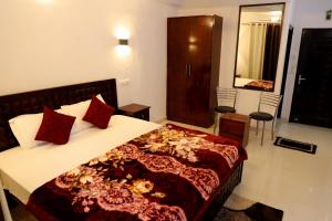a bedroom with a large bed with red pillows at Royal Inn Rewalsar in Malther