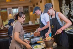 a group of people in a kitchen preparing food at Sawasdee Village in Kata Beach