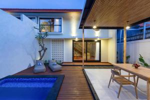 a house with a pool and a table and chairs at Paisa Villa Seminyak in Seminyak