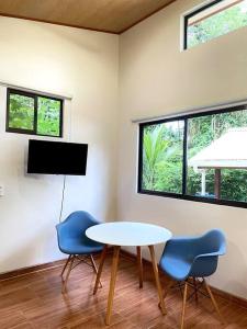 Zimmer mit einem Tisch, 2 Stühlen und einem TV in der Unterkunft CASA NOIL, Beautiful Eco House near the beach! in Puerto Viejo