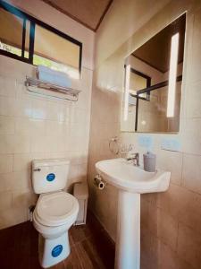 a bathroom with a white toilet and a sink at CASA NOIL, Beautiful Eco House near the beach! in Puerto Viejo
