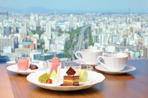 a table with plates of desserts and cups of coffee at Nagoya Prince Hotel Sky Tower in Nagoya