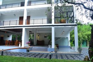 a large white house with a balcony at Eden Grand in Dambulla
