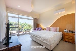 a bedroom with a bed and a television and a balcony at 月牙灣 in Xiaoliuqiu