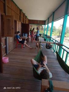 a group of people laying in hammocks on a deck at Tavan Seng 3 in Don Det