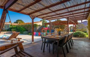 a patio with a table and chairs under a pergola at Amazing Home In Loborika With Heated Swimming Pool in Loborika