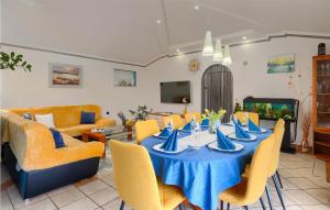 a dining room with a blue table and yellow chairs at Amazing Home In Loborika With Heated Swimming Pool in Loborika