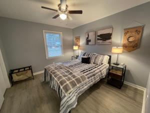 um quarto com uma cama e uma ventoinha de tecto em Remodeled Cottage With Sunroom em Manchester