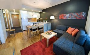 基蒂萊的住宿－Levi Chalets，一间带蓝色沙发的客厅和一间厨房