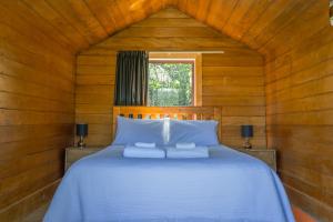 ein Schlafzimmer mit einem Bett in einer Holzhütte in der Unterkunft Mount Cook Station Shearers Quarters Lodge in Lake Tekapo