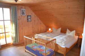 ein Schlafzimmer mit einem Kinderbett in einer Holzhütte in der Unterkunft Kollerhof in Neunburg vorm Wald
