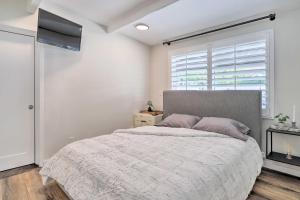 a white bedroom with a large bed and a window at Less Than 1 Mi to El Paseo Cottage Oasis with Fire Pit in Palm Desert