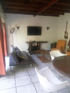 a living room with a tv and a table and chairs at Casa de campo Miramar Norte in Miramar