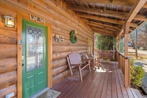 a cabin with a green door on a wooden porch at Five-Bedroom House in Sevierville