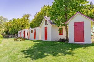 a row of houses with red doors in a yard at Mount Cook Station Huts in Lake Tekapo